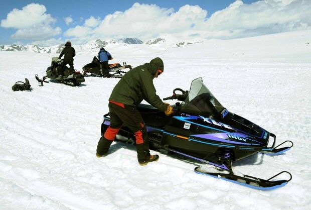 Snowboard Camp workers start their snowmobiles